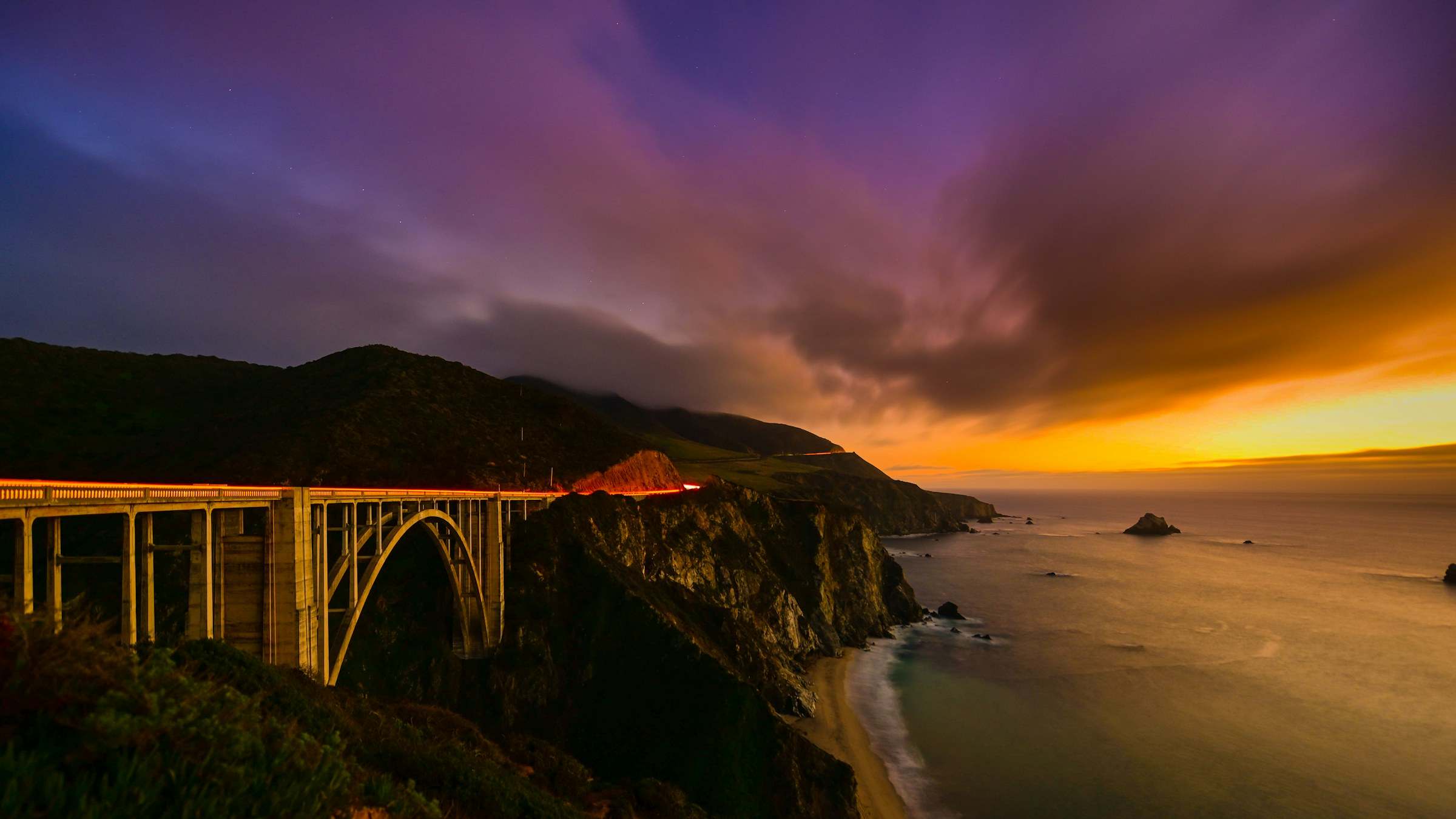 Bixby Bridge on the Big Sur coast under a purple and orange sunset