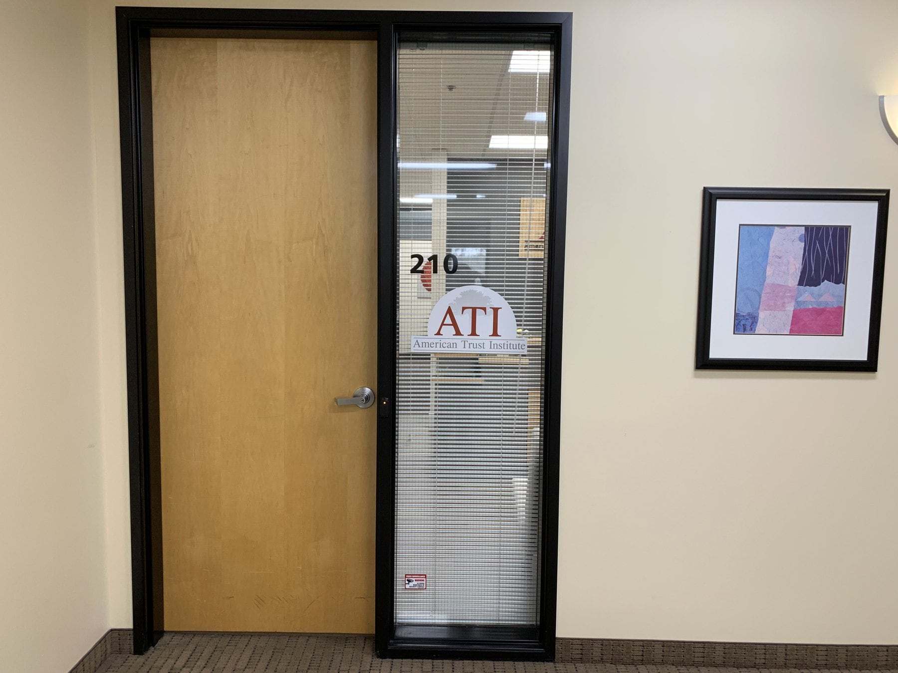 The door to Suite 210 with the American Trust Institute sign