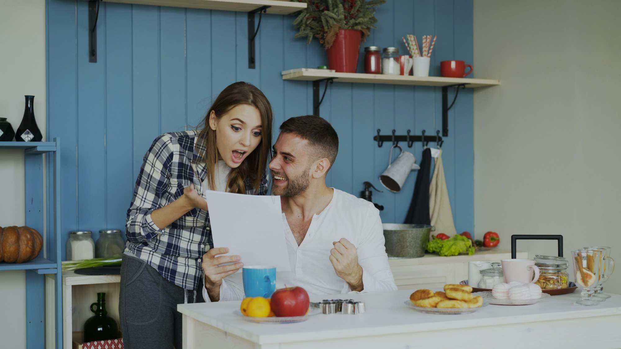 Couple smiling as they read a document in their kitchen