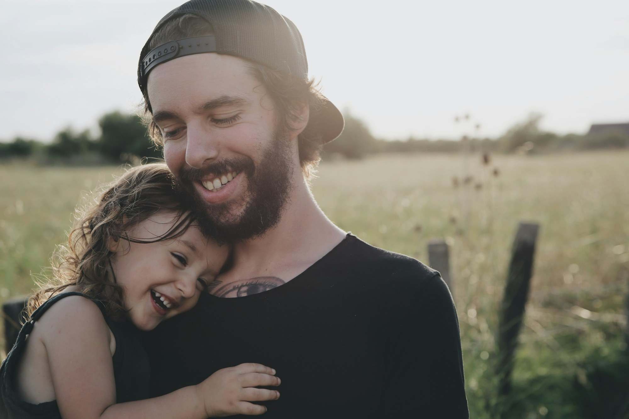 Father holding his laughing daughter outdoors
