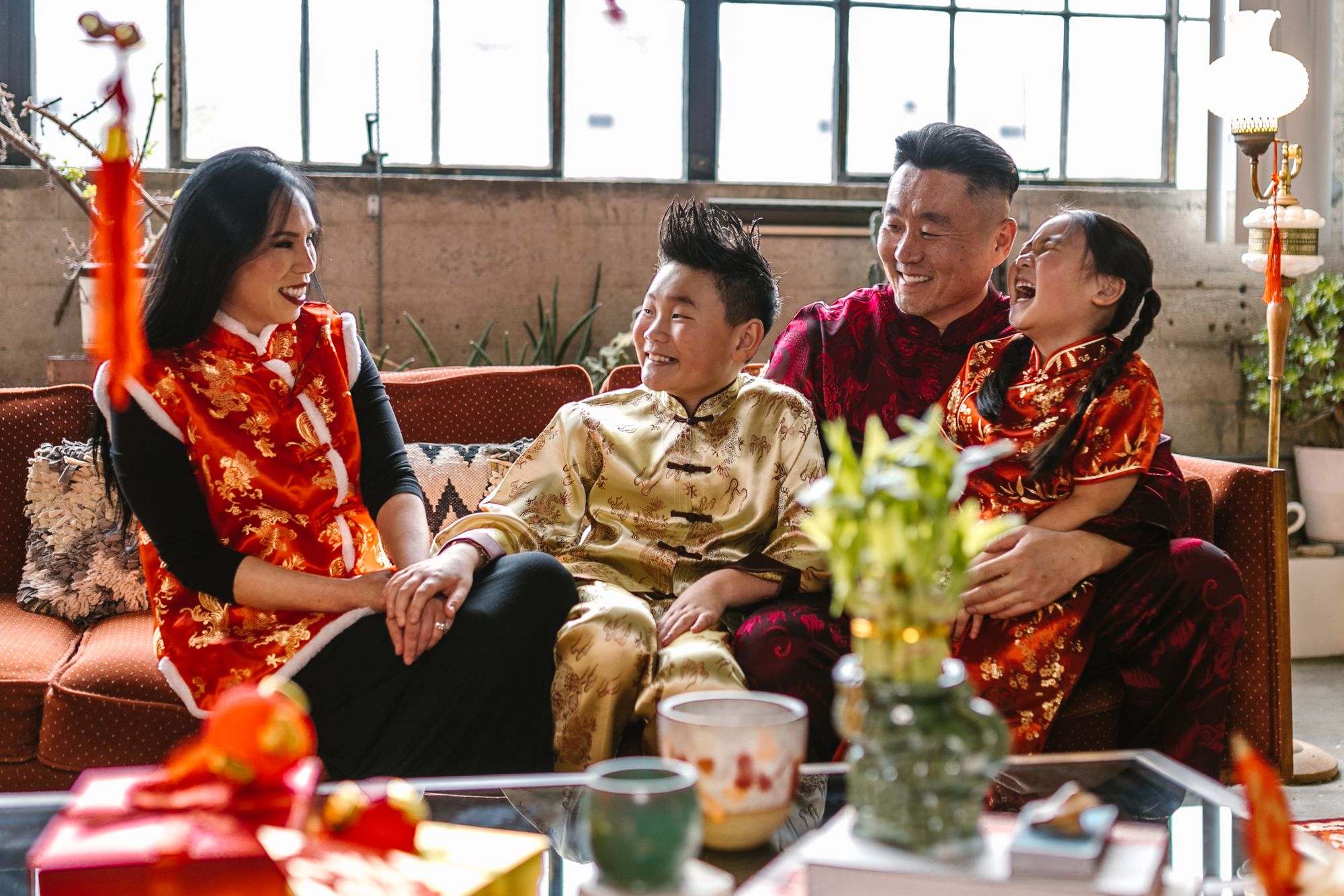 Family laughing together in festive red outfits during Lunar New Year